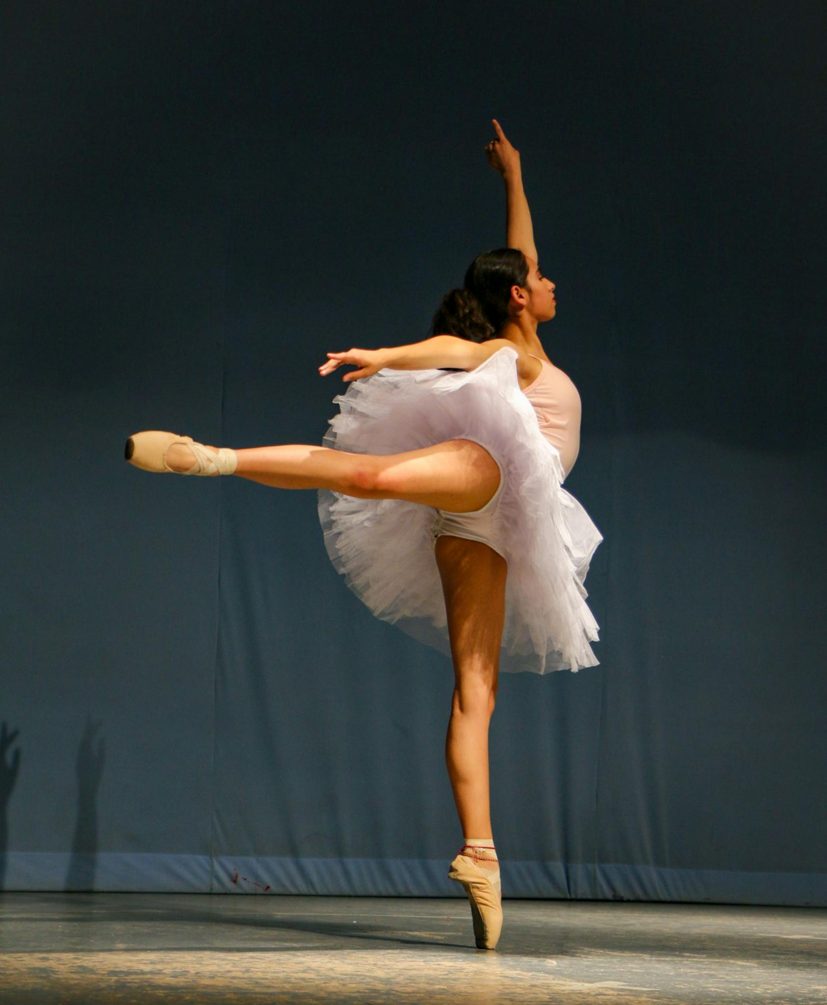Ballet dancer performing a graceful arabesque on stage in Lerma de Villada, Mexico.